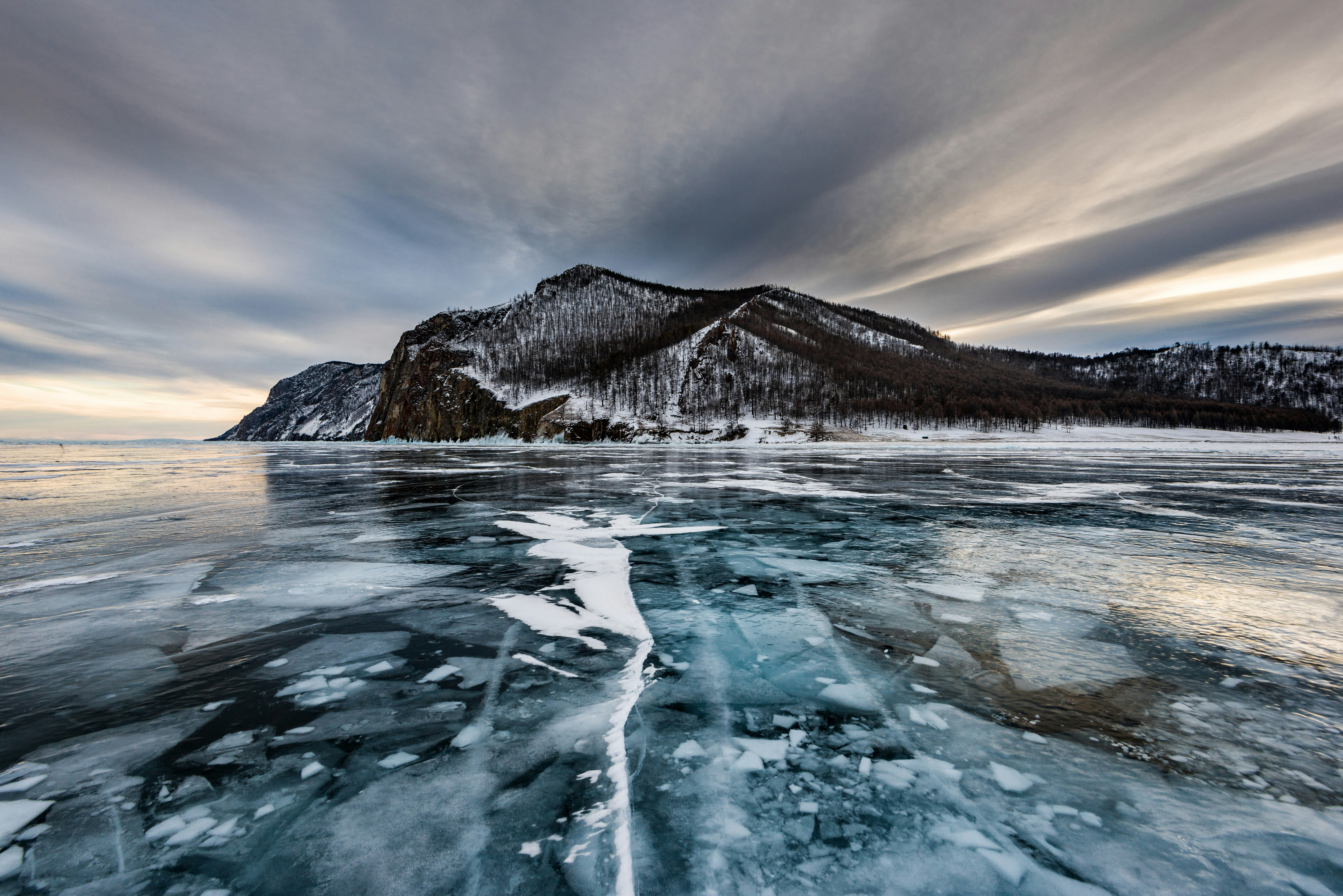 melting ice on water near gray mountain at daytime